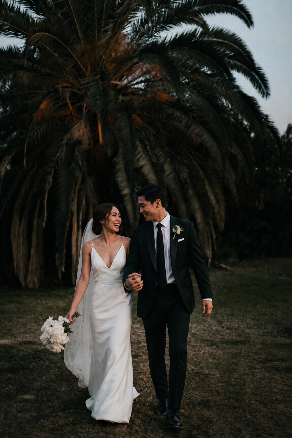 Bride and groom holding hands at sunset
